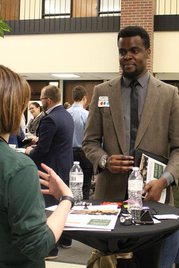 Male student talks to visiting business professionals at the Backpack-to-Briefcase professional networking event.